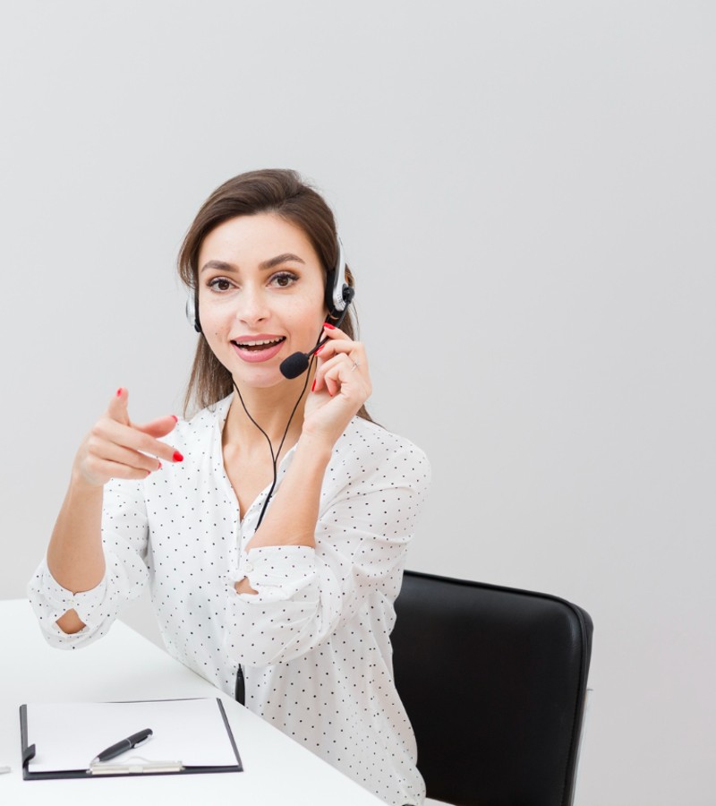 front-view-woman-desk-wearing-headset-pointing (1)