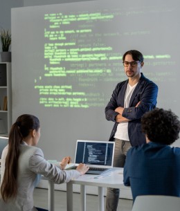 teacher-university-with-his-arms-crossed-chest-making-presentation-group-students-while-standing-by-large-screen (1)